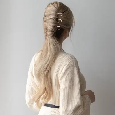 Long, blonde French pin ponytail hairstyle viewed from back