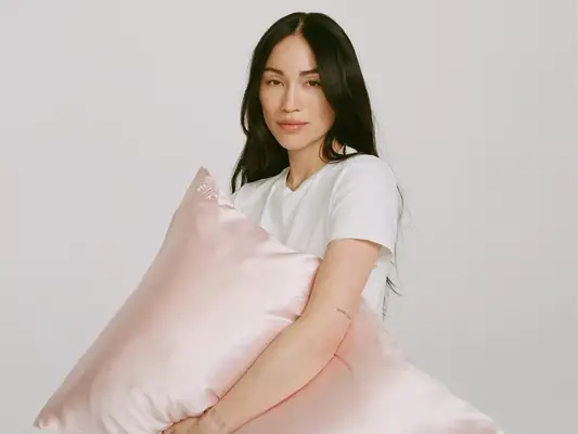 steph shep holding pink pillow on white background 