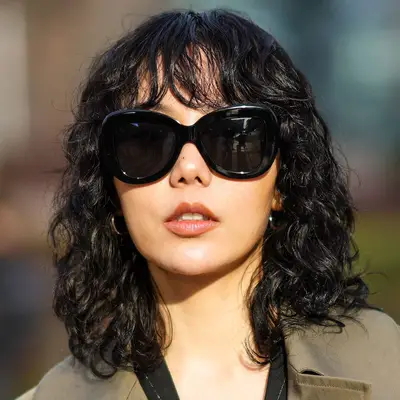 Xiayan wears a curly wolf cut hairstyle with bottleneck bangs