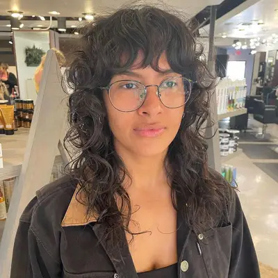 Woman with collarbone-length curly shag wolf cut hairstyle