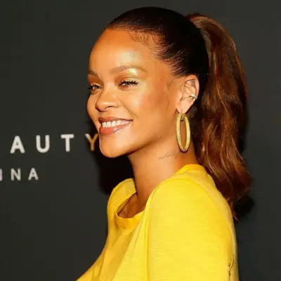 Rihanna with auburn-hued brown hair in a ponytail