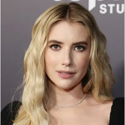 Emma Roberts with neutral blonde hair with soft brunette roots