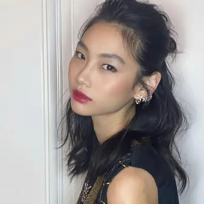 A messy half-up, half down hairstyle on actor Hoyeon 