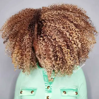 A woman with short brown curly hair and a black sporty elastic headband