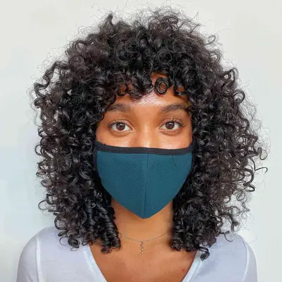 A woman with a curly, shaggy wolf cut hairstyle