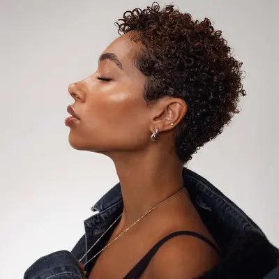 A woman with a short curly pixie cut hairstyle