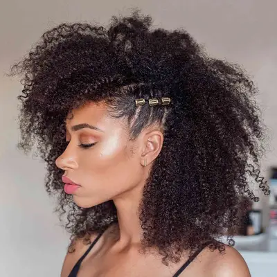 A woman with coily natural hair with one braid on the side