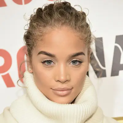Jasmine Sanders with curly blonde hair in a low romantic updo at the 2018 Roc Nation Pre-Grammy Brunch in New York City