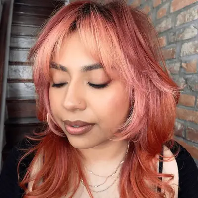 Woman with curly strawberry blonde hair with highlights