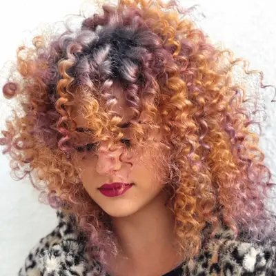 Curly, spiraled hair with pink, orange, and strawberry blonde highlights
