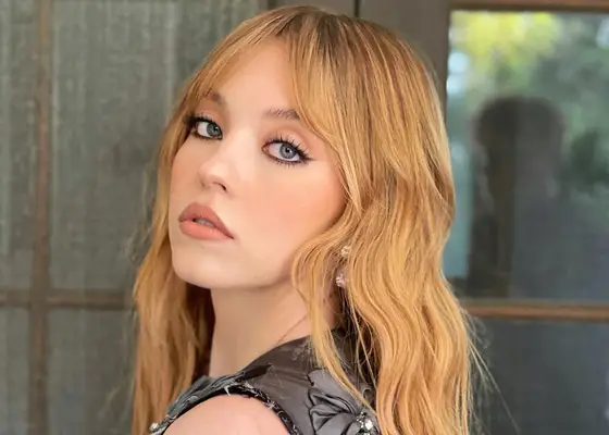 Sydney Sweeney looking over her shoulder indoors