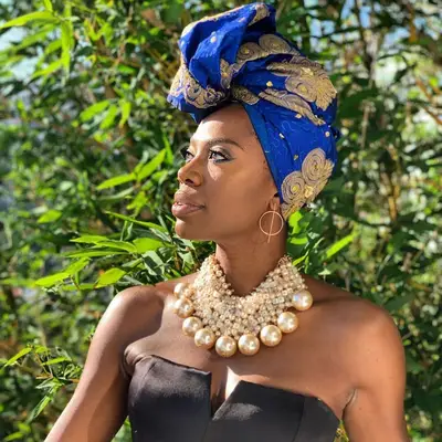 Yvonne Orji wearing a blue and gold headwrap