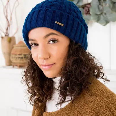 A woman with curly hair wearing a satin-lined cap