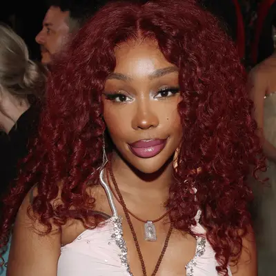 SZA with burgundy curls