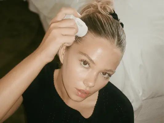 Model applying a hair stying stick