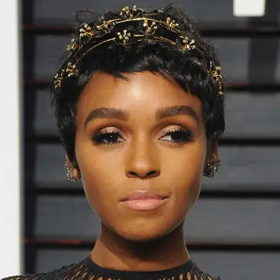 Janelle Monae wears a delicate double wired gold headband with bejeweled flowers in her short, shoppy pixie cut