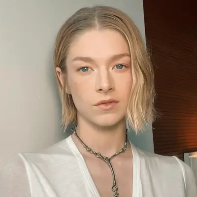 Hunter Schaffer wears an imperfect middle part, undone waves and white tee to a beauty event in NYC