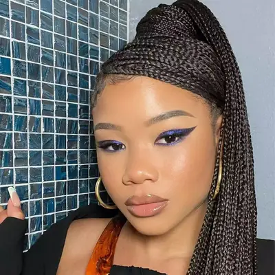 Storm Reid wearing knotless braids in a side-parted ponytail