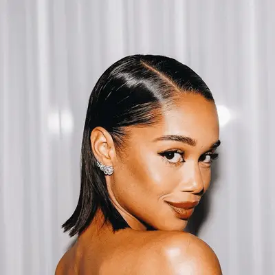 Laura Harrier with shoudler length slicked back hair with side part