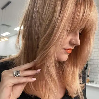 warm peach blonde hair color with bangs