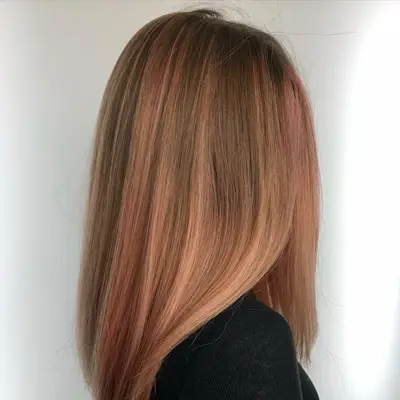 Medium-length straight hair with soft peach highlights
