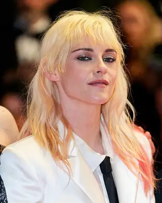 Kristen Stewart with light blonde hairstyle wearing a white outfit