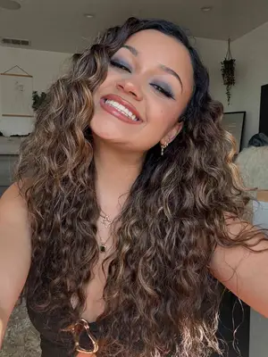 Madison Bailey smiling with long curly hair
