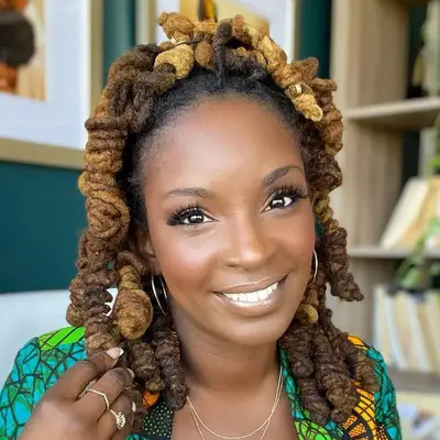 Woman with curly ombre locs in half-up hairstyle with fresh, radiant makeup look