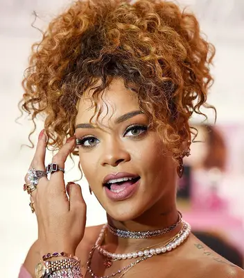 Rihanna wearing a curly copper and brown ponytail at the RiRi by Rihanna fragrance unveiling in Brooklyn, New York