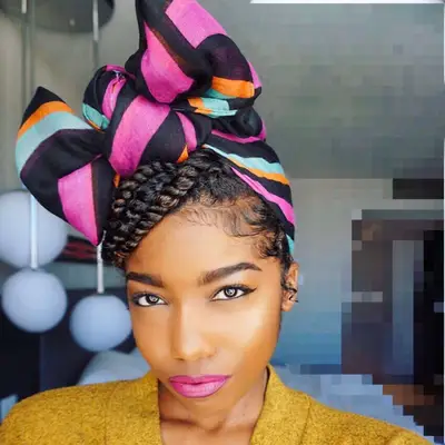 Woman with twist hairstyle wrapped in colorful scarf tied in a bow
