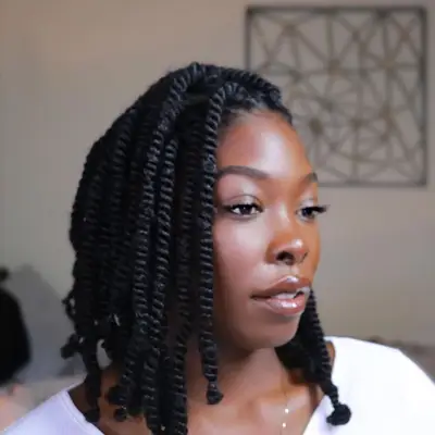 Woman with shoulder-length spring twists hairstyle secured with elastic at ends