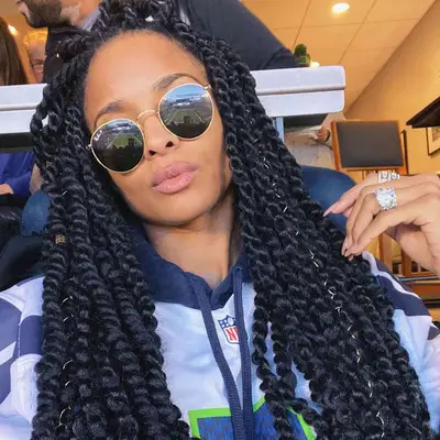 Ciara wears long boho twists with gold string on accent pieces