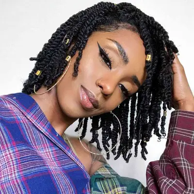 Woman with side-swept short twists and gold accent beads