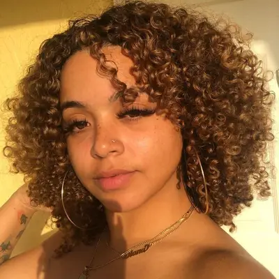 Woman with warm, bronze curls in sunlight