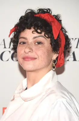 Alia Shawkat with curly hair and a headband