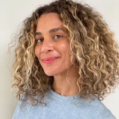 Woman with blonde natural curls and silver-toned platinum highlights