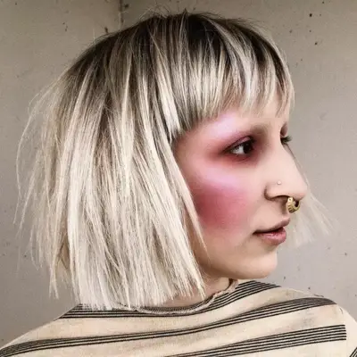 Woman with a blunt platinum blonde and bleached eyebrows