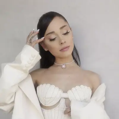 Ariana Grande with updo adorned with pink flowers and loose tendrils