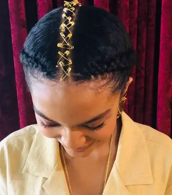 Yara Shahidi updo with braids and gold safety pins