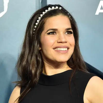 America Ferrera in black dress with loose waves and pearl headband