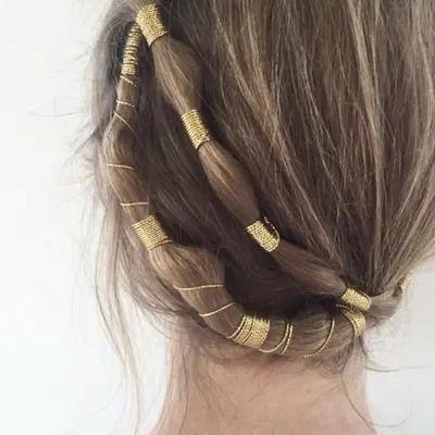 Updo hairstyle with gold rope twisted throughout