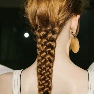 Red hair in four-strand low braid down back