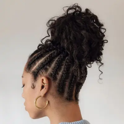 Woman wears high, curly bun with braids at roots
