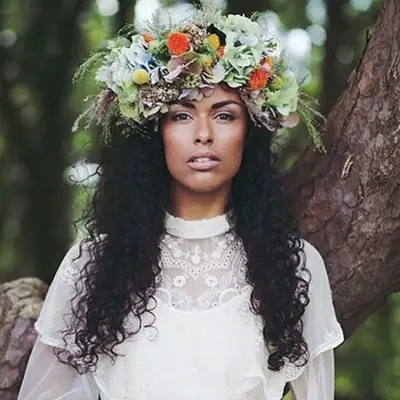 Bride wears long, curly hair with large flower crown