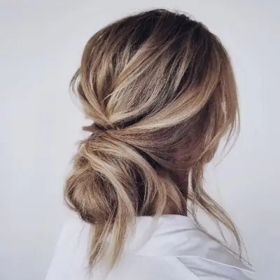 Low twisted bun with loose pieces