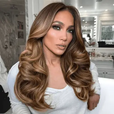 J. Lo with center parted waves and deep purple eye makeup