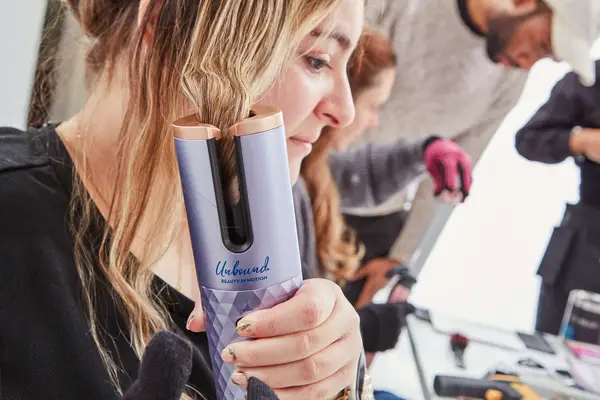 Person curling their hair with the Conair Unbound Rechargeable Cordless Auto-Curler Curling Iron