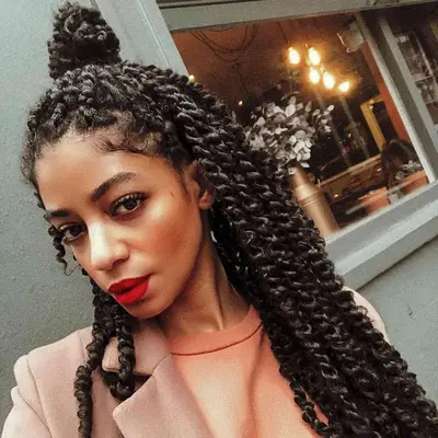 Woman with red lipstick and a passion twists hairstyle in a half-up topknot