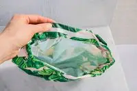 A hand holding the Kitsch Satin-Lined Luxury Shower Cap