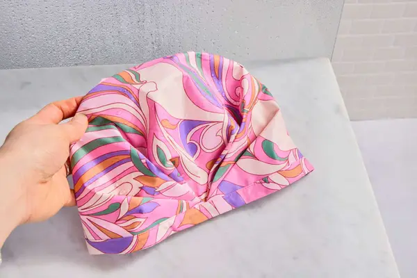 A pink SHHHOWERCAP on a bathroom counter